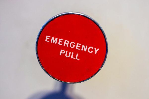 A red emergency pull lever mounted on a wall