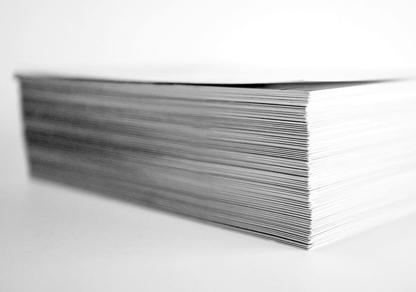A tall stack of printed papers