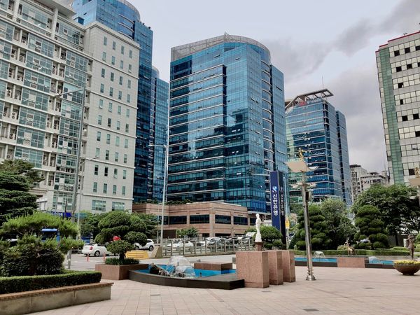 Tall office buildings in Seoul against a pale sky