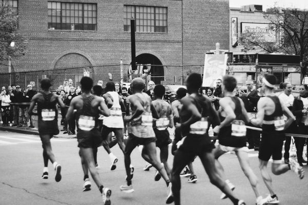 Black and white photo of men running in a marathon on a city street