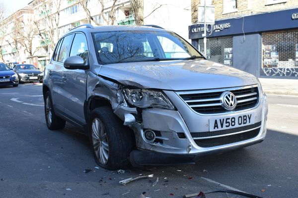 A car with a dented side panel after being hit by another car