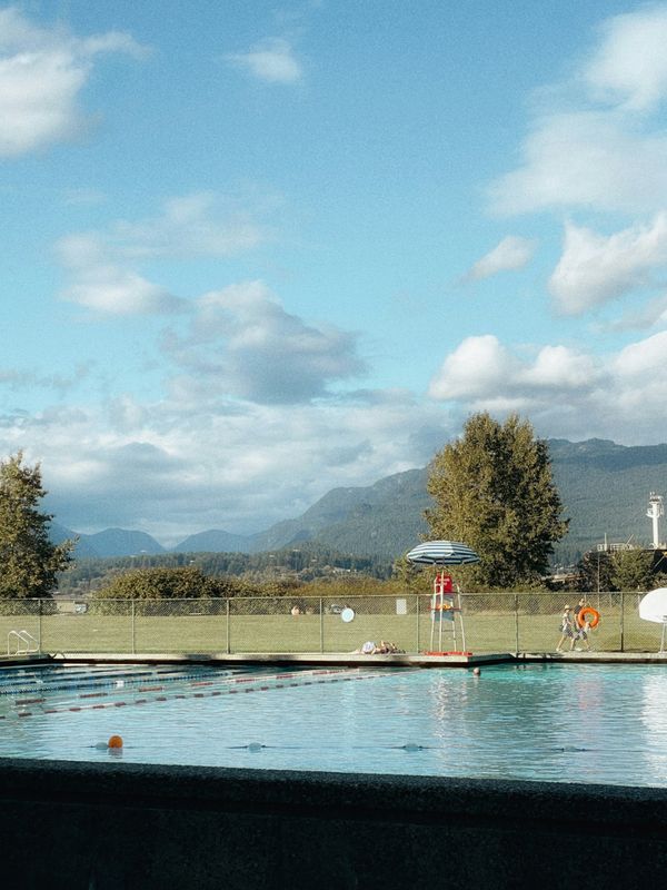 An empty swimming pool with a lifeguard chair at the edge