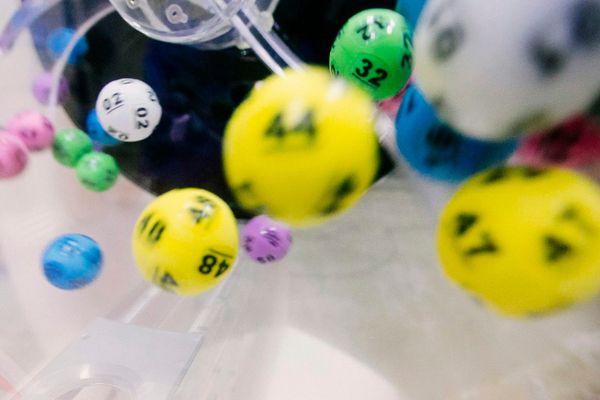 Numbered lottery balls tumbling inside a clear mixing machine