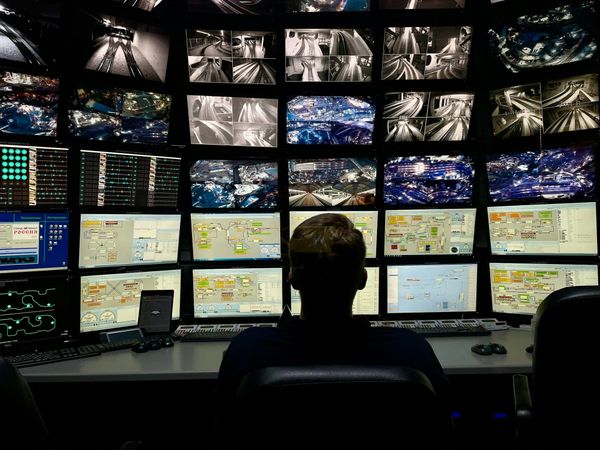 A man sitting in front of several computer monitors