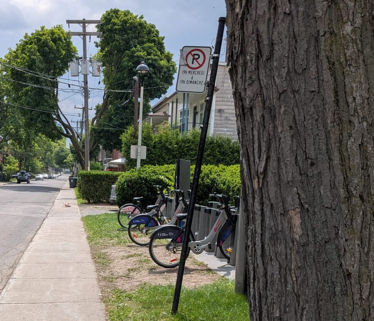 photo: Bixi bike station; small child's bicycle toppled on the sidewalk symbolically further up