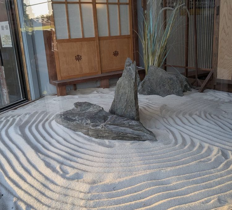 photo: zen garden: whorls of sand with slabs of rock in the middle