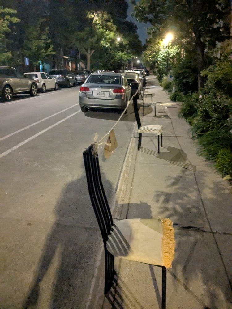 photphoto: 'Montreal Dibs': chairs on a sidewalk with a rope tied between them to mark off a parking spot