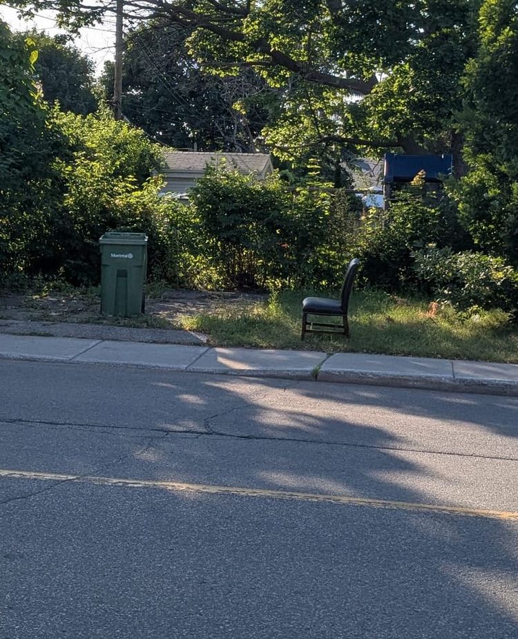 photo: chair by a curb w/ waste receptacle