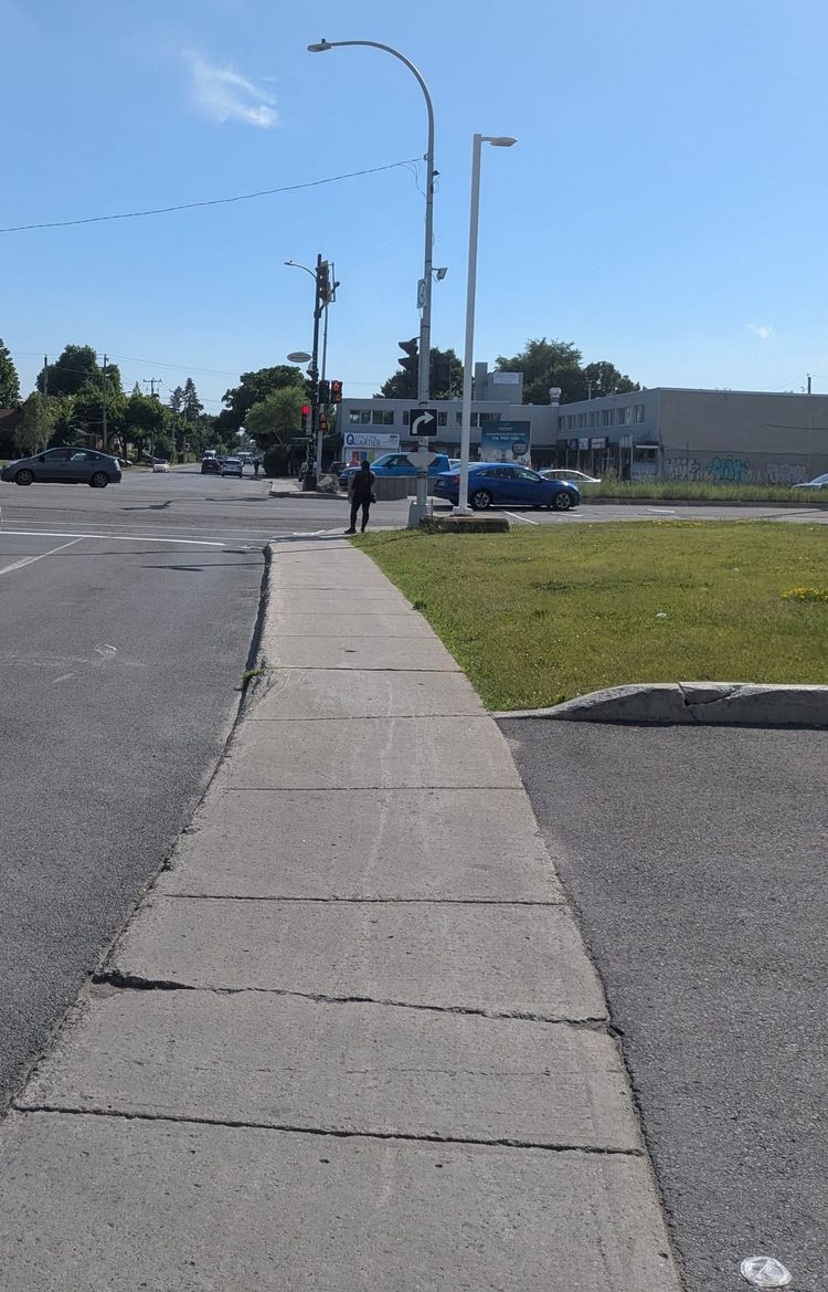 photo: sidewalk stretching toward an intersection on a sunny day