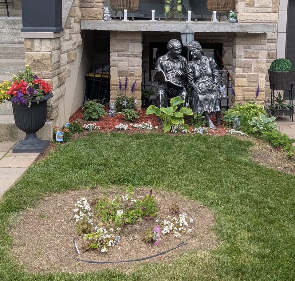 photo: statue of a couple on a bench in the front yard of a house