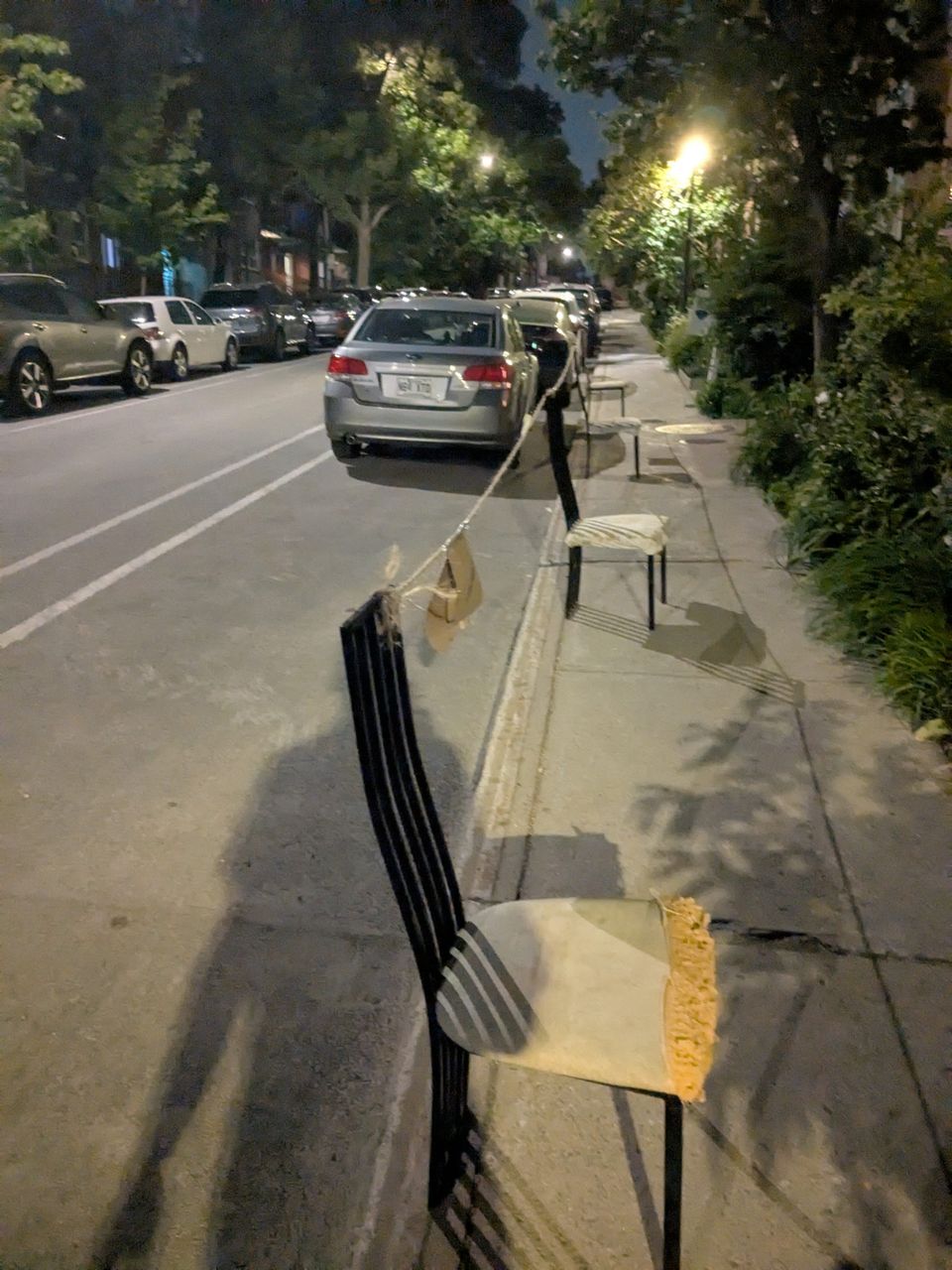 photphoto: 'Montreal Dibs': chairs on a sidewalk with a rope tied between them to mark off a parking spot