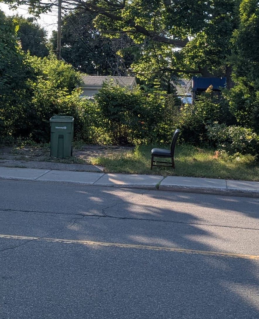 photo: chair by a curb w/ waste receptacle