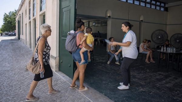 Famílias e idosos entram em um abrigo temporário climatizado durante uma onda de calor em Portugal
