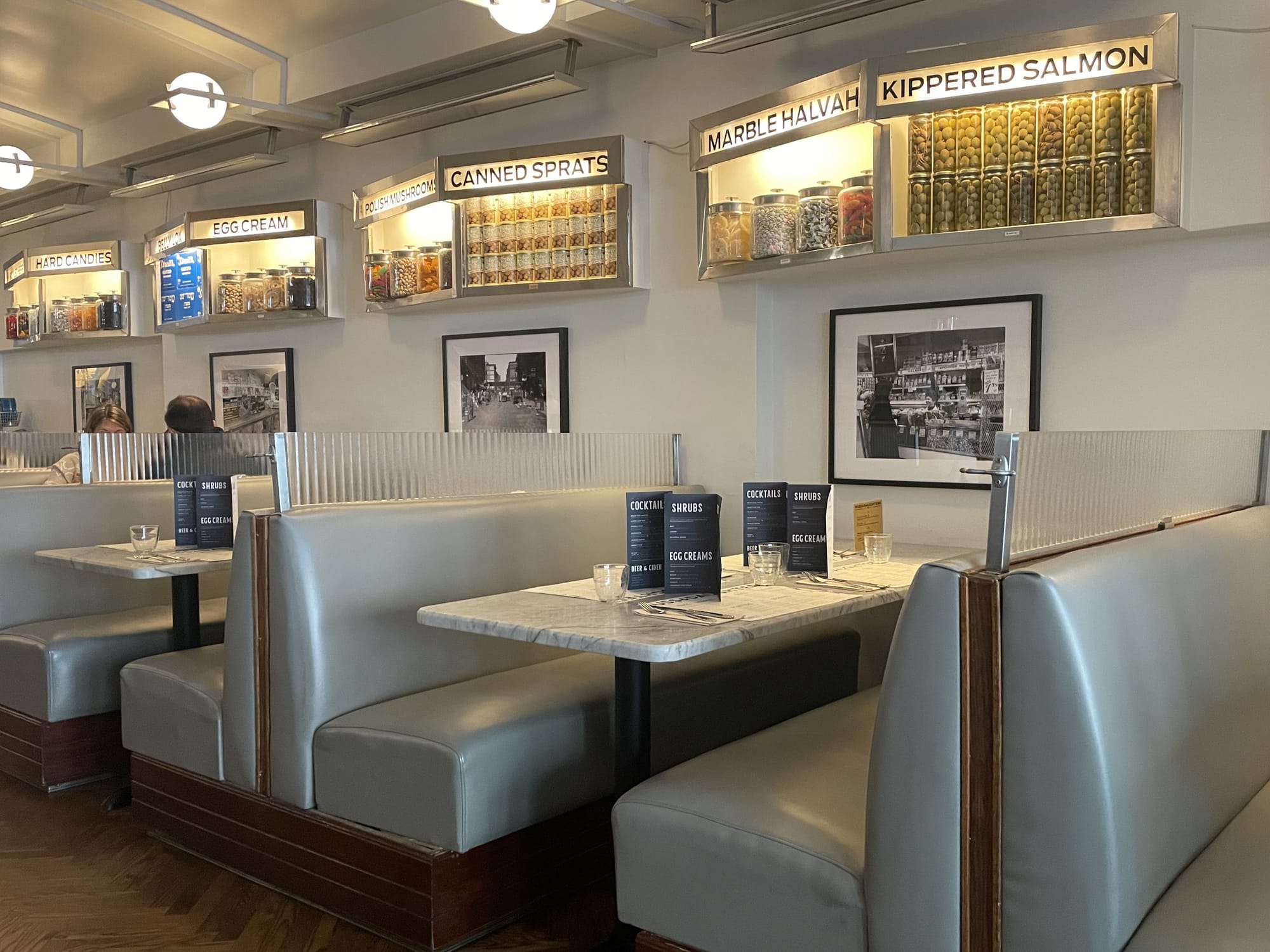 Dining room at Russ & Daughters Cafe, decorated with black-and-white historic photos and vintage shelves of dry goods