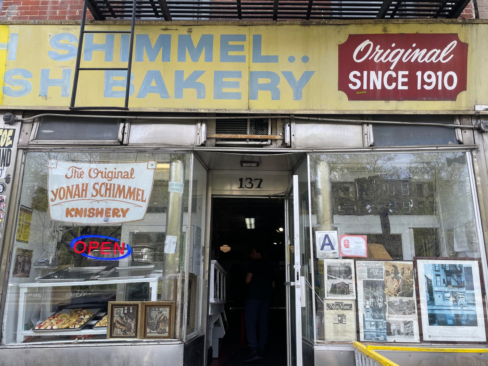 Narrow storefront with signs reading "Original since 1910" and "The Original Yonah Schimmel Knishery"