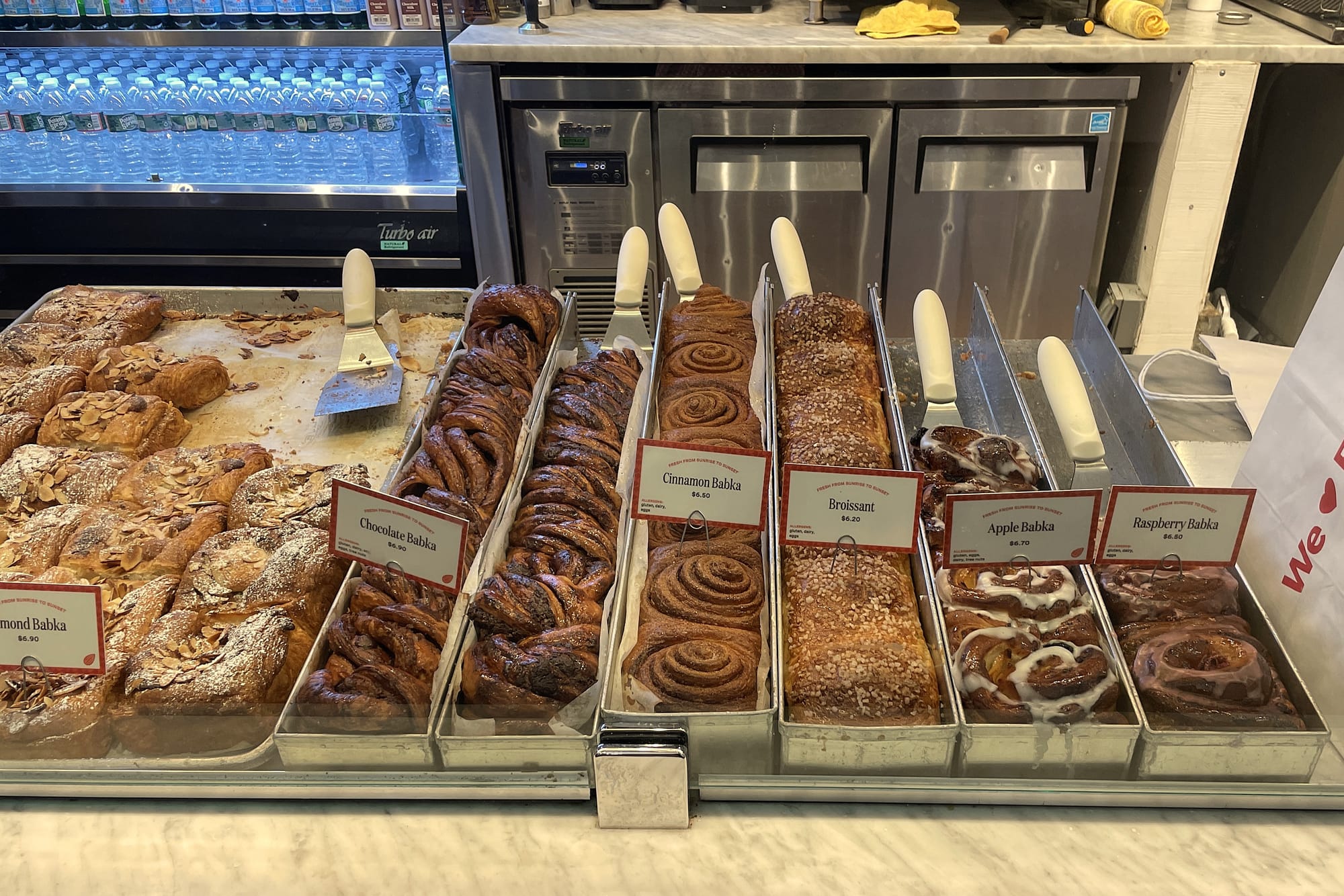Counter with several long trays of different flavors of babka