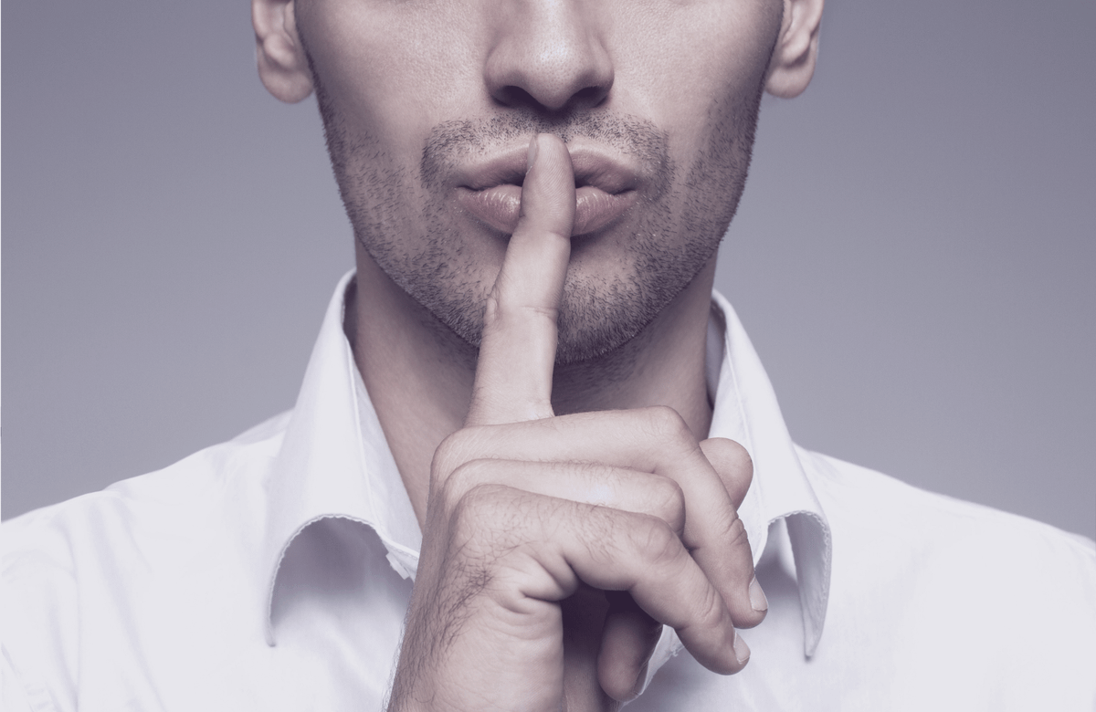 Mann in weißem Hemd legt den Zeigefinger auf die Lippen – Geste des Schweigens, Duotone in Tintenlila. Titelbild des Whitepapers „Die Kosten des Schweigens".