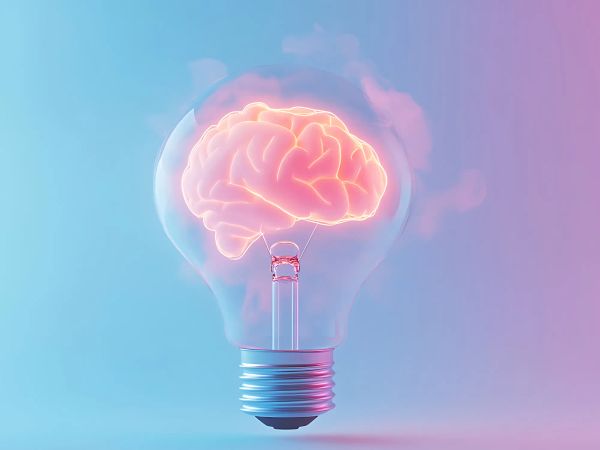 A glowing brain inside a light bulb against a gradient blue and pink background, symbolizing creativity and ideas.