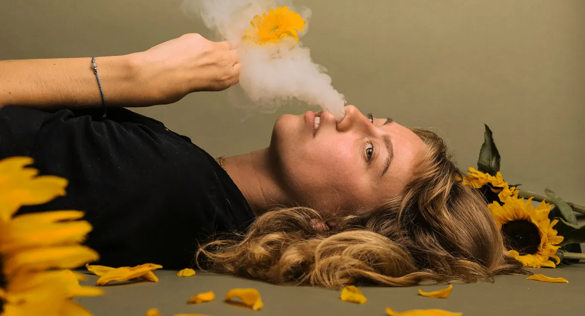 Femme qui sent fleur et fumée