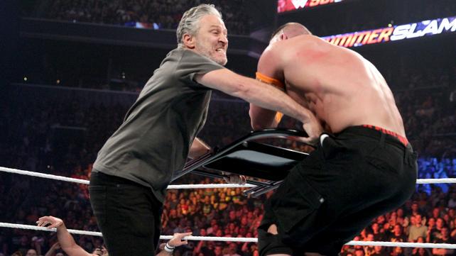 Jon Stewart slamming chair into a wrestler in a WWE ring