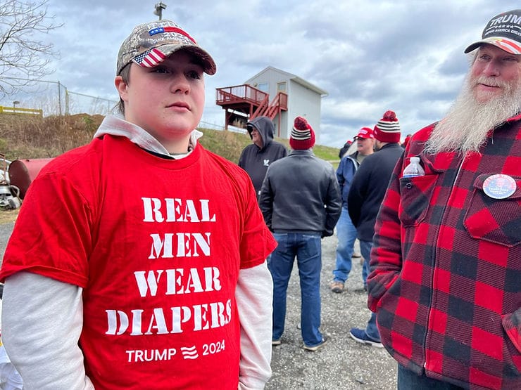 A teenager wearing a "Real Men Wear Diapers" t-shirt