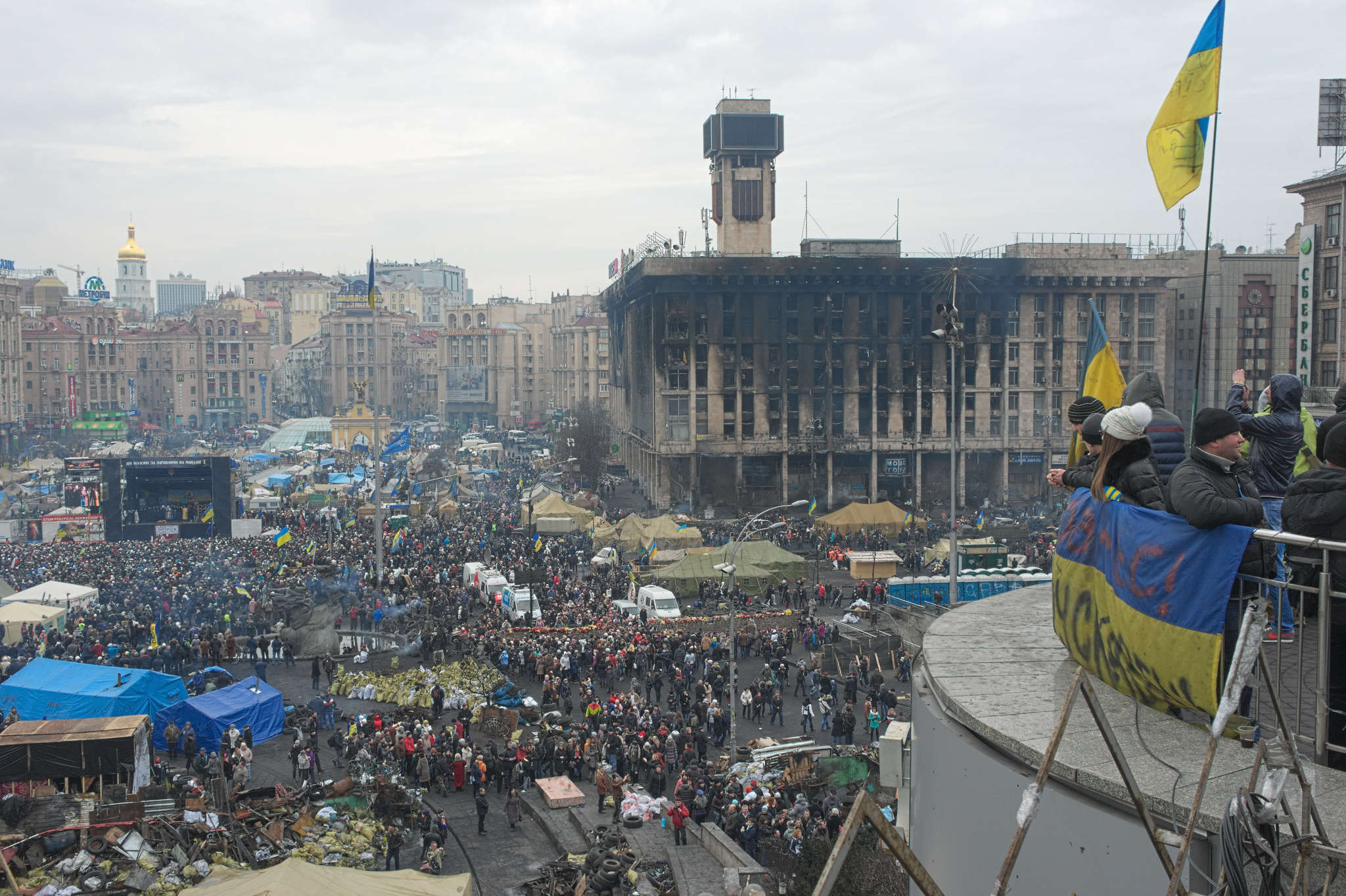 A photograph taken from a high vantage point showing the multitude of people, sandbags, tents, and other structures and facilities at Kyiv's Independence Square