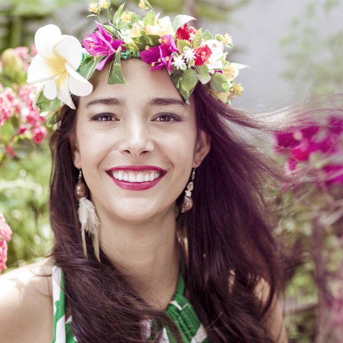 A woman wears a flower crown with the wind blowing in her hair.
