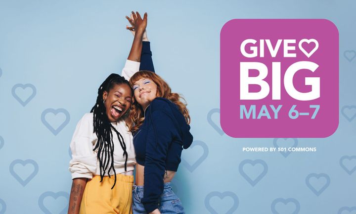 Image of two women smiling holding hands in front of a heart background.