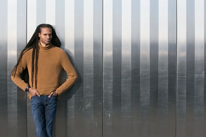 In front of a silver wall, Stacy D. Flood stands looking at the camera.
