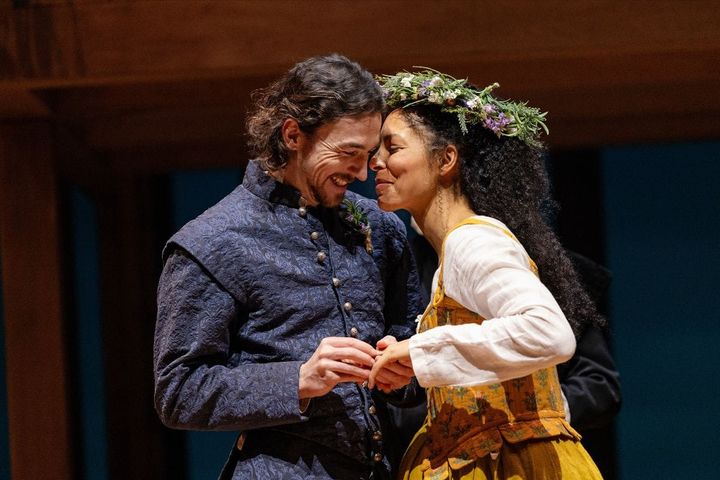 A man and woman dressed in 17th century clothing are getting married. Shakespeare puts a ring on Agnes finger, they look happy and in love.