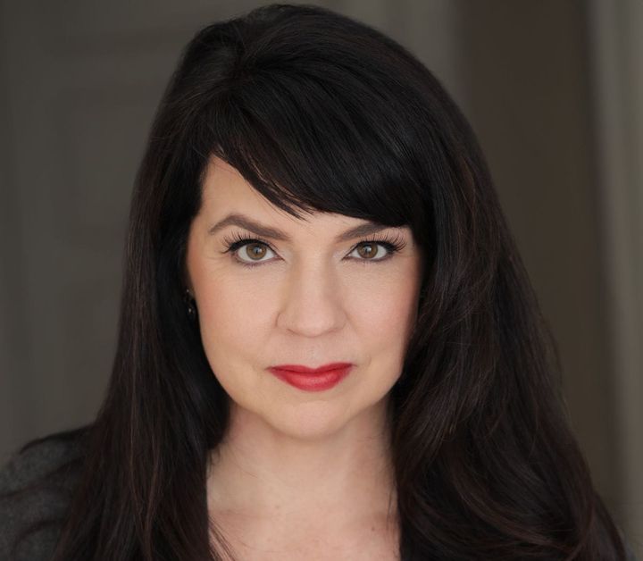 A headshot of Kelly Kitchens. She looks straight at the camera with a slight smile.