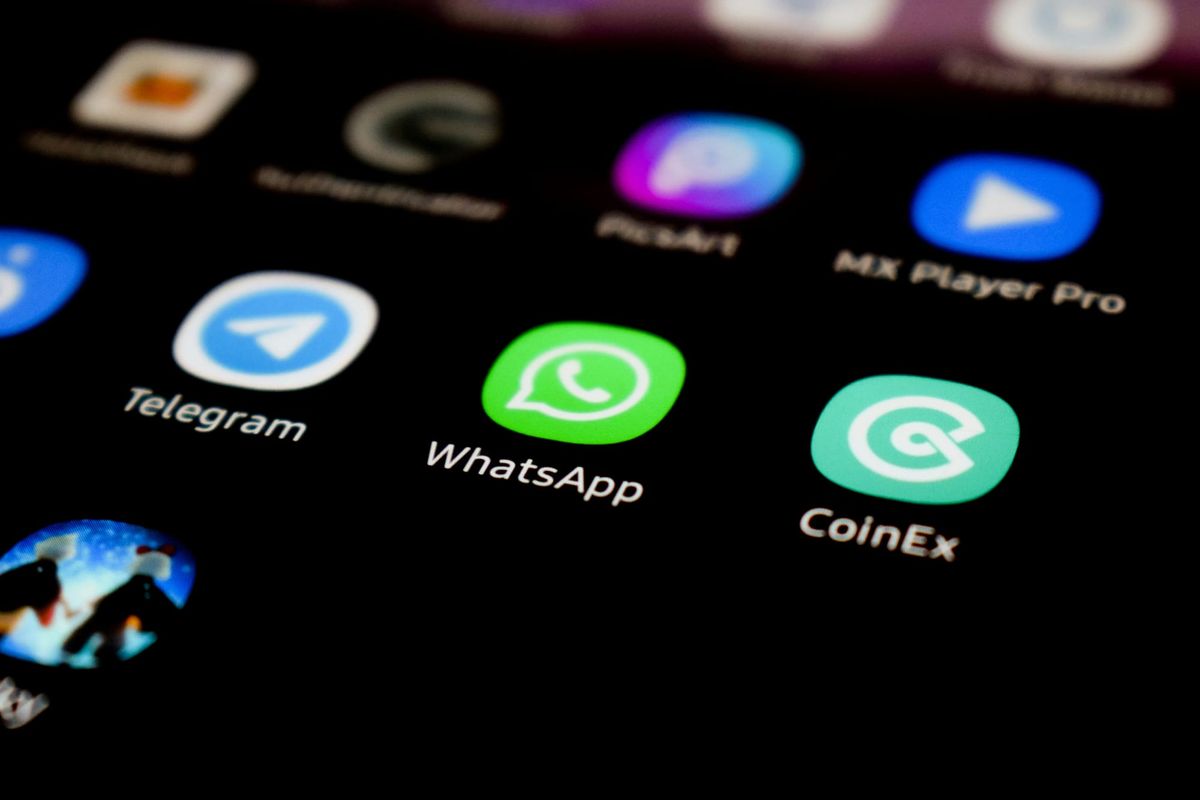 Smartphone con schermata WhatsApp Business aperta su scrivania da lavoro
