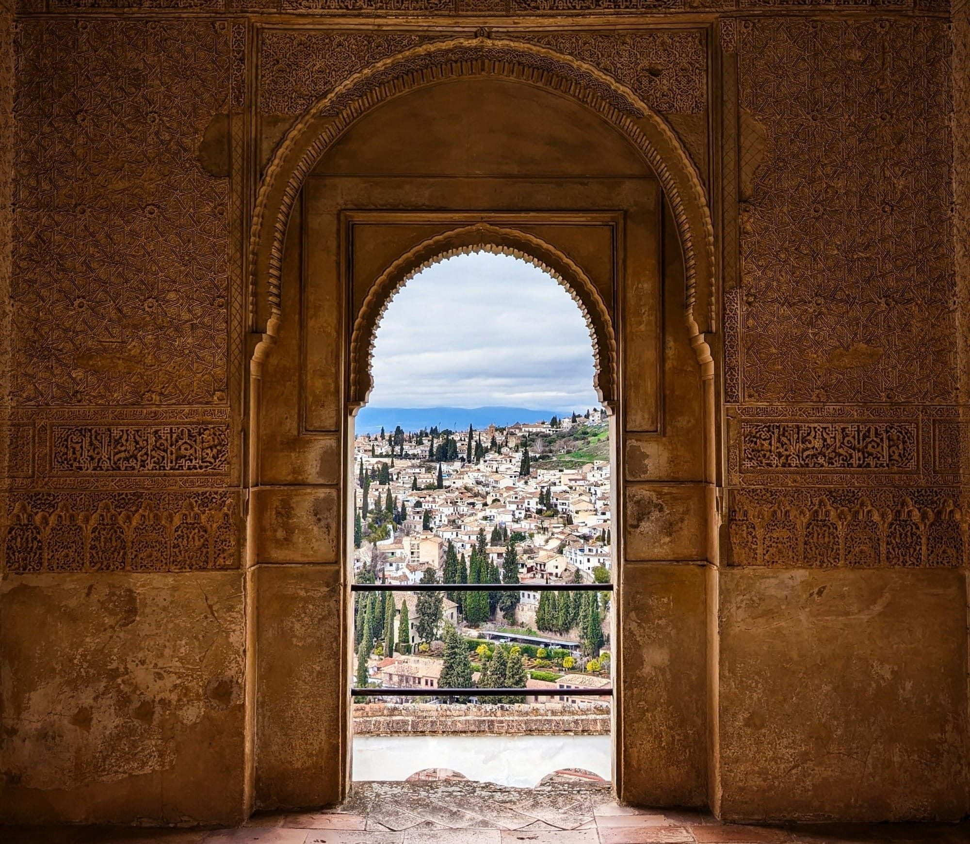 an archway with a view of a city in the distance