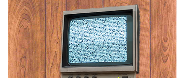 A CRT security monitor from the 80's with wood paneling in the background. Only static is on the screen.