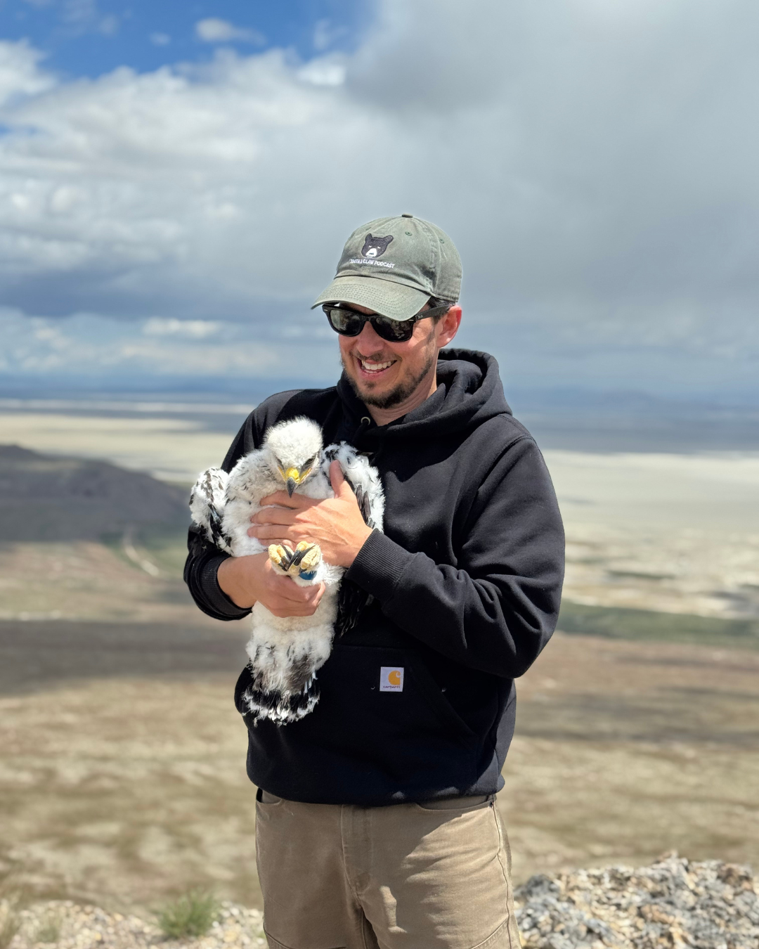 Man holding baby bird of prey