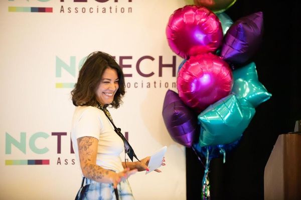 Stacy Whitenight delivering the keynote at the NC TECH Women’s Summit 2025 in Wilmington, speaking on stage about navigating the seasons of life and career as a woman in tech.