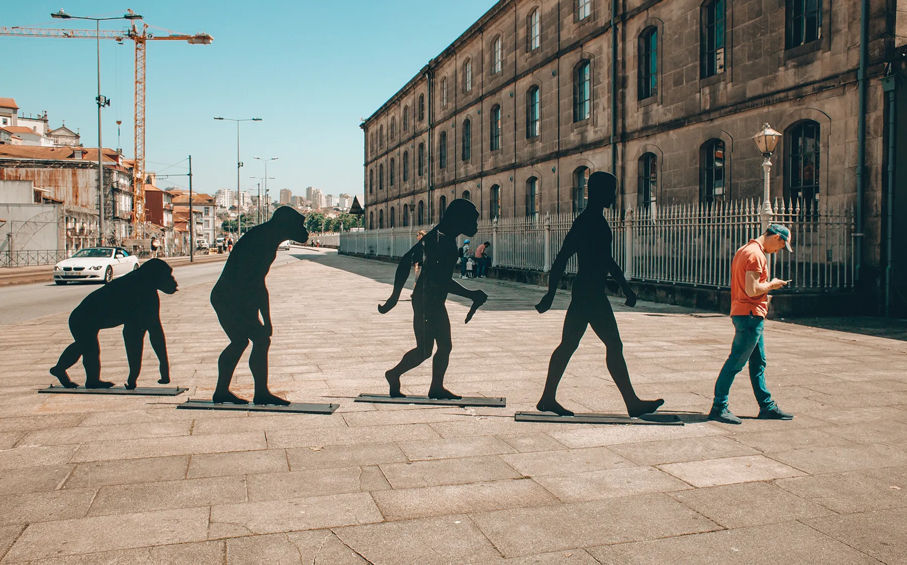 Man walking in front of evolution art installation