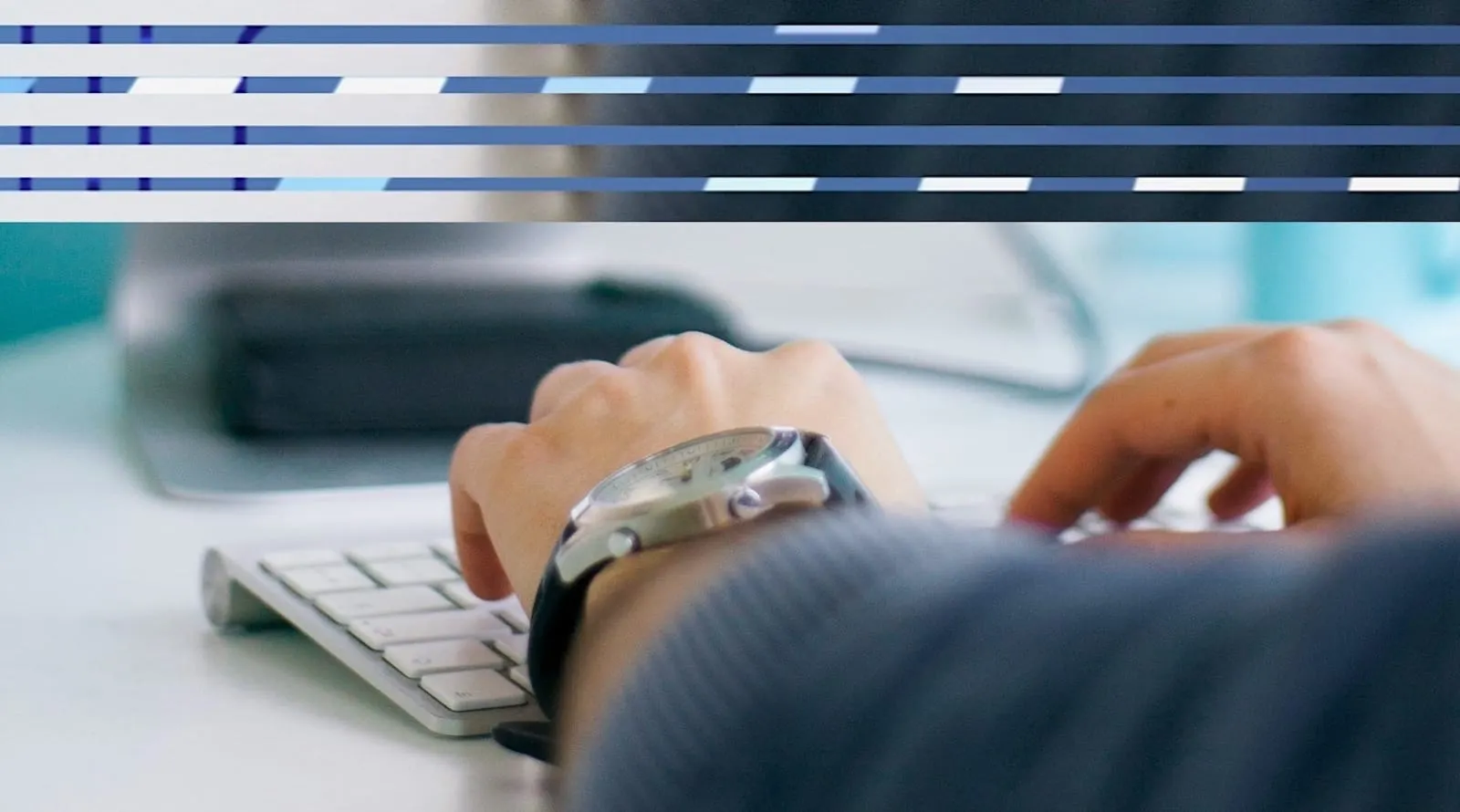 Person's hand with watch on keyboard 