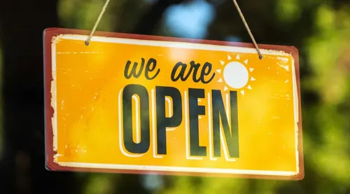 Yellow sign that says "we are open"