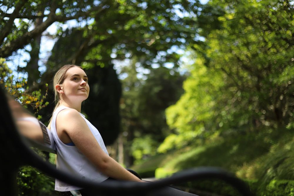 Woman sitting on a bench in greenery post image