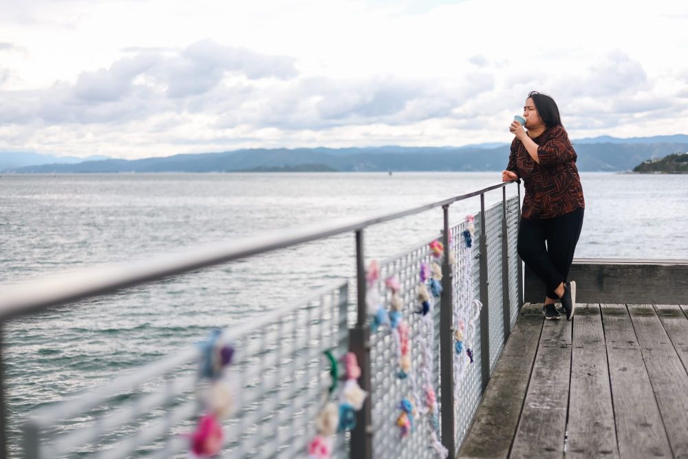 Woman enjoying coffee by the waterfront post image