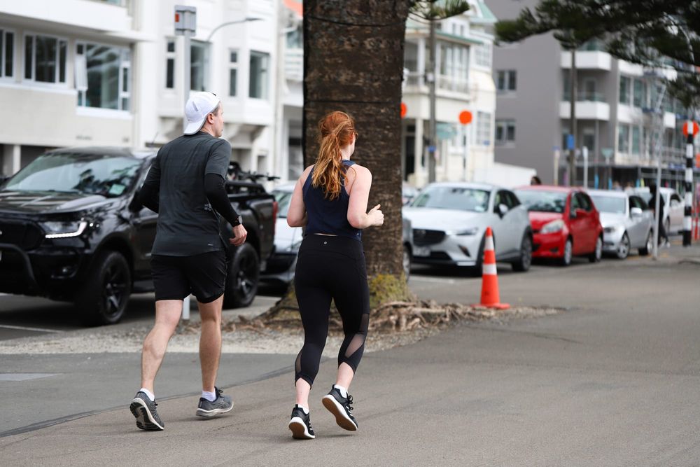 Couple jogging along city street post image
