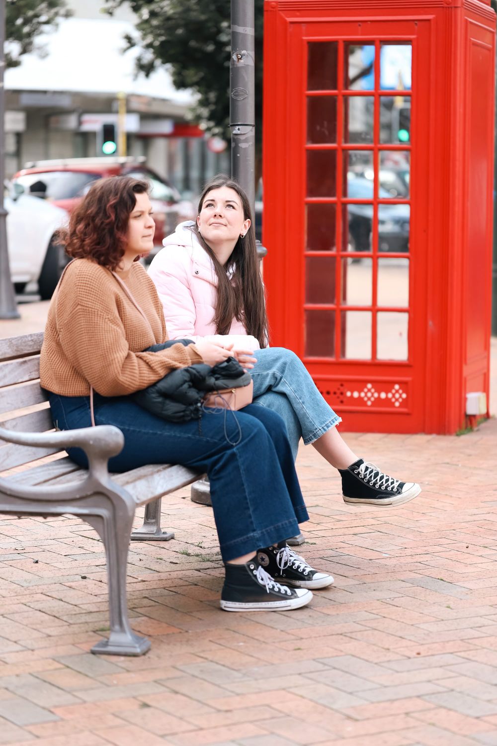Friends on bench with red phone booth post image