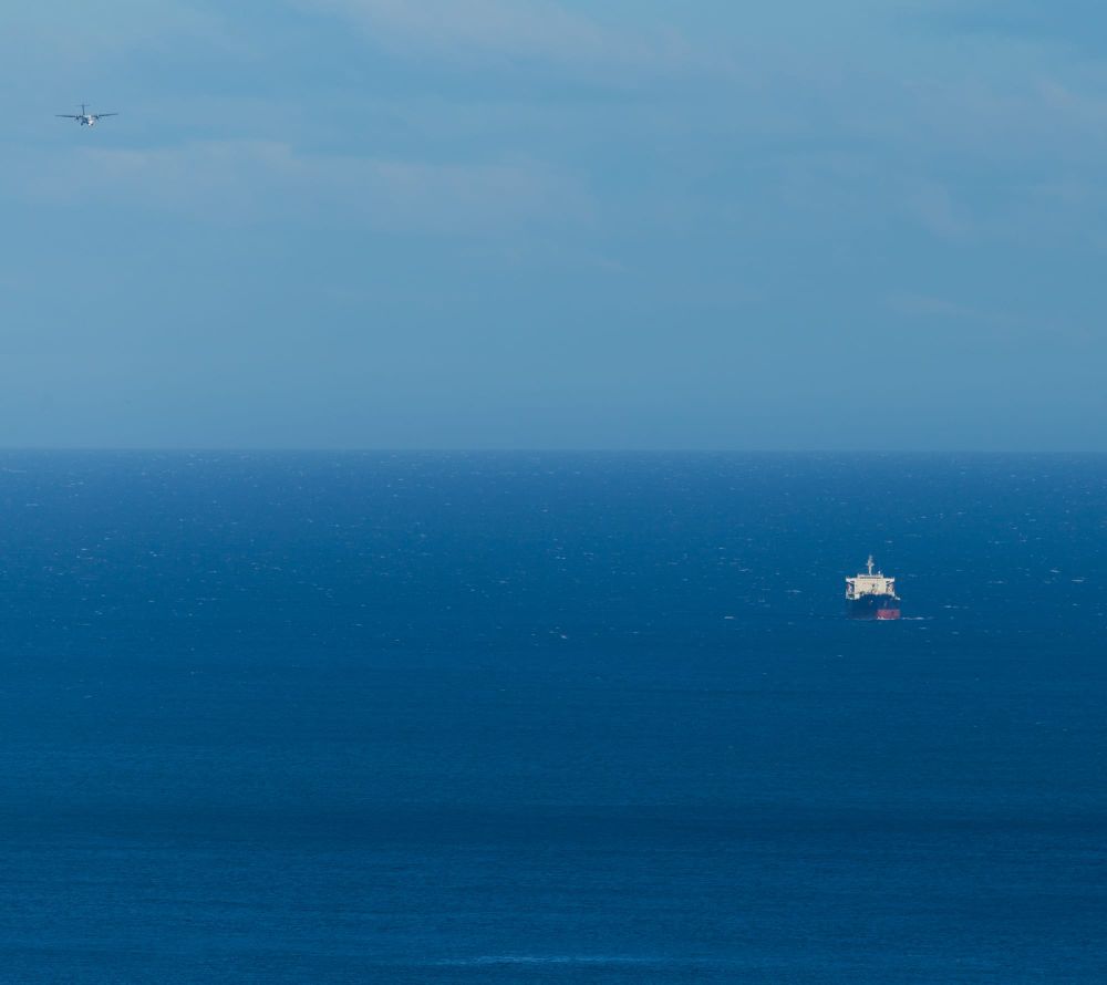 Ship and plane over open ocean post image