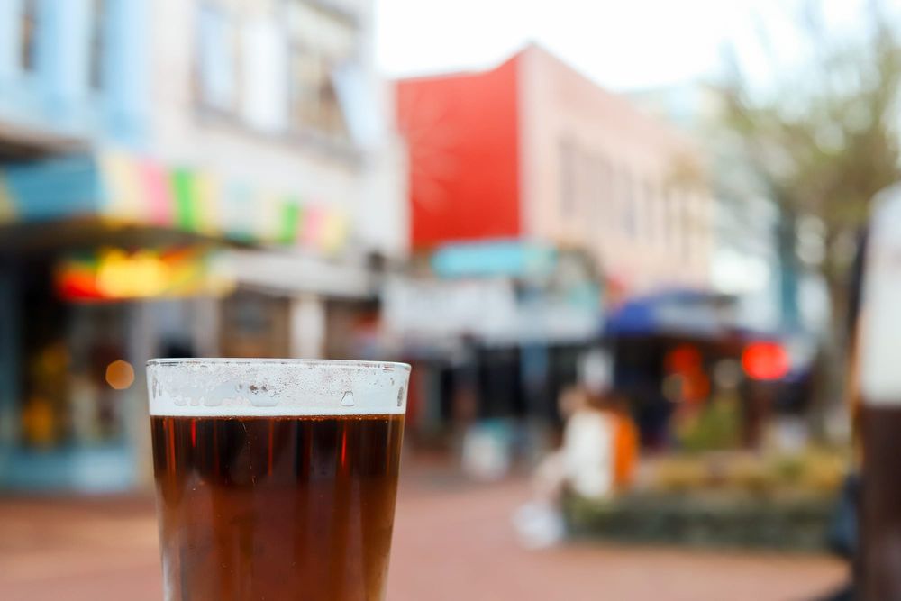 Single glass of beer with blurred street post image