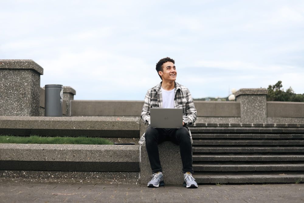 Smiling student with laptop post image