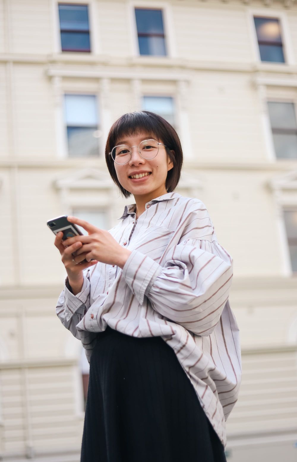 Woman smiling and holding phone outdoors post image