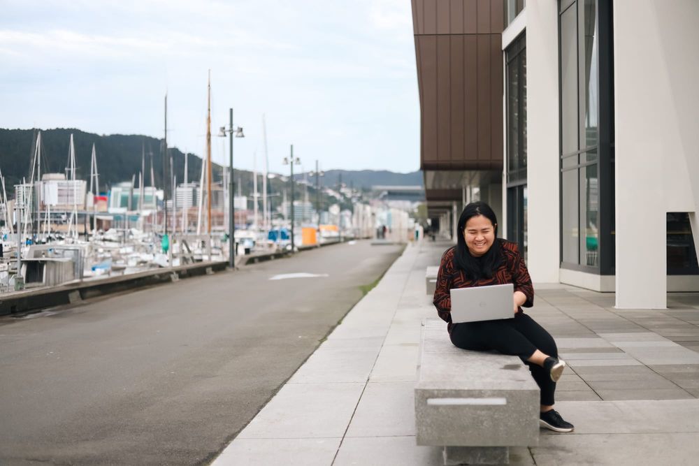 Woman smiling while working on laptop by marina post image