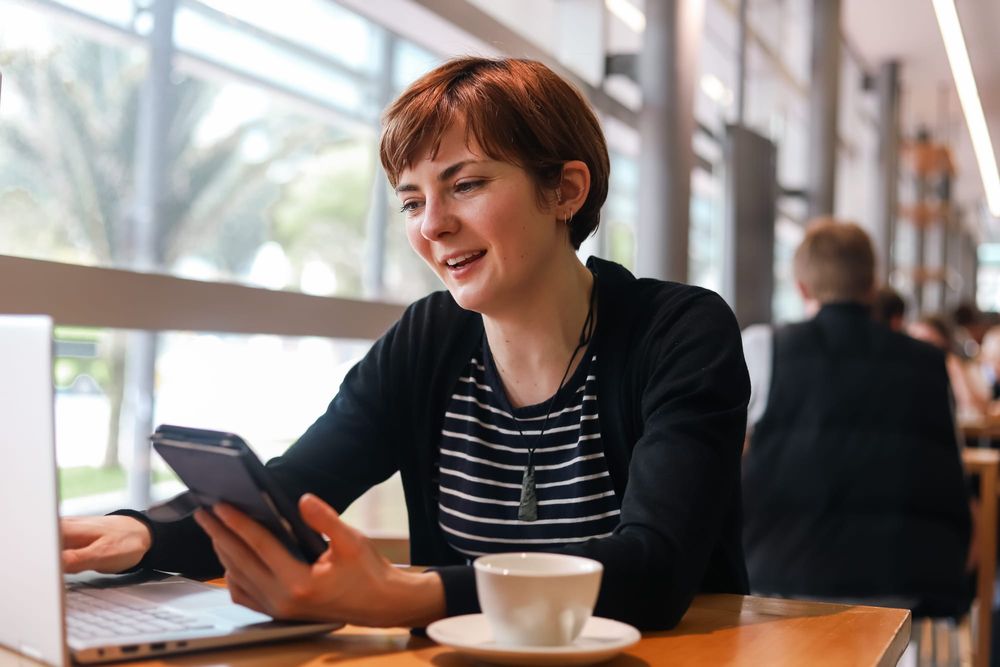 Woman chatting on phone at cafe table post image