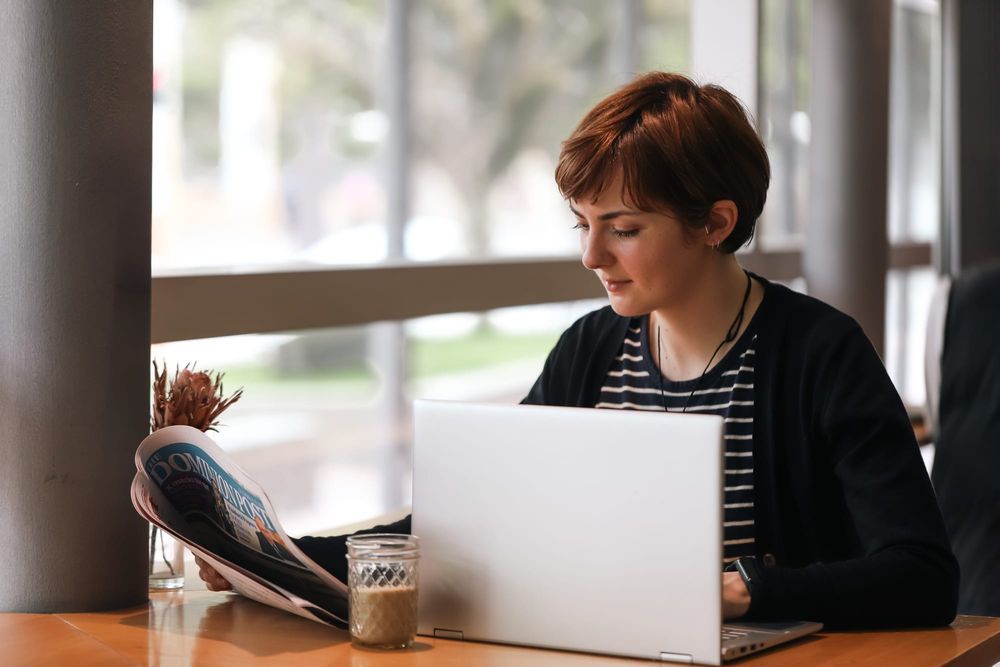 Woman reading newspaper in cafe post image